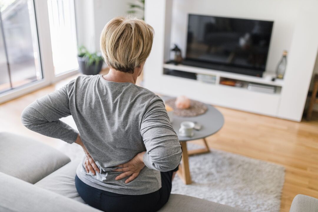 Una mujer está preocupada por el dolor de espalda en la región lumbar. 
